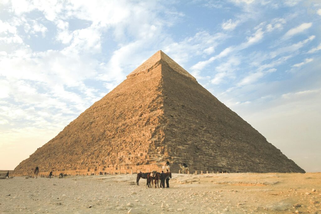 Désert du Caire pyramide prise de jour avec 3 cheveaux et deux hommes devant